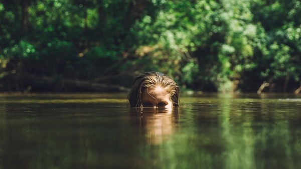 Una mujer emerge de un lago